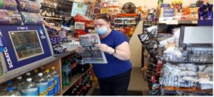 Elaine buying a newspaper at the local shop 